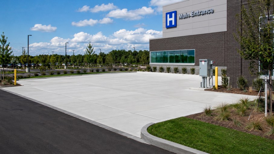 Prepared concrete pad and utility connections outside a hospital main entrance